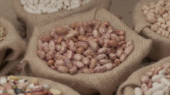 Dry Borlotti beans falling on jute bowl at slow motion. Mediterranean diet vegetarian vegan ingredie