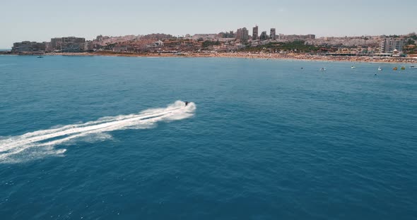 Drone Following Fast Riding Hydrocycle Approaches to the Beach of Tourist City