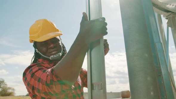 African Black Man Engineer Climbing on the Leders of the Silio System 