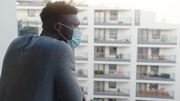 Lonely Black Man with Medical Mask on the Balcony. Quarantine and Mental Health Problems