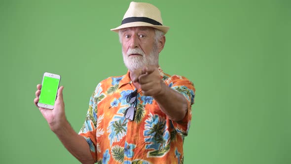 Handsome Senior Bearded Tourist Man Ready for Vacation Against Green Background