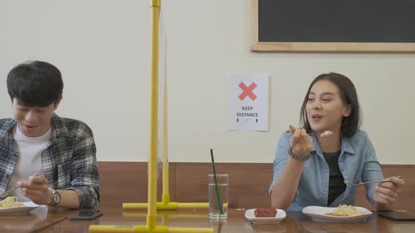 Women sitting in restaurant eating food and keep distance