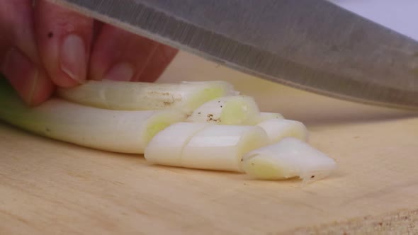 Close Up   Chopping Two Scallions On Cutting Board