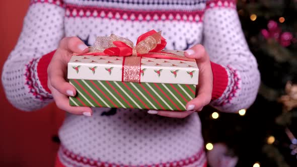 Close Up Young Woman Gives Gift. Concept of Holidays, Christmas and New Year.