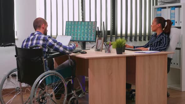 Paralysed Financial Expert Sitting in Wheelchair Analysing Economy