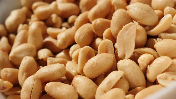 Bowl of groundnut snack food slow tilting background 4K 2160p UltraHD video - Salted and roasted sna