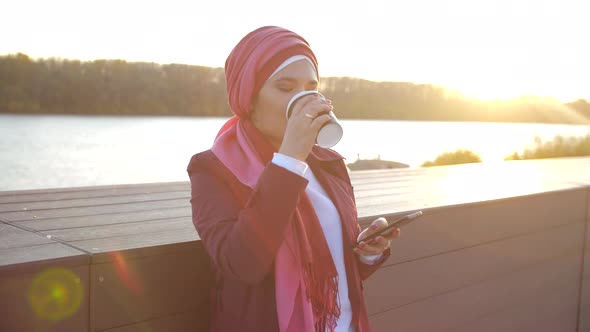 Young Muslim Woman Wearing Hijab Having Coffee Break Outdoor on City Background