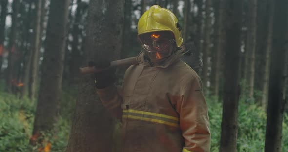 Portrait of Firefighter with Full Equipment Holds the Axe in His Hand