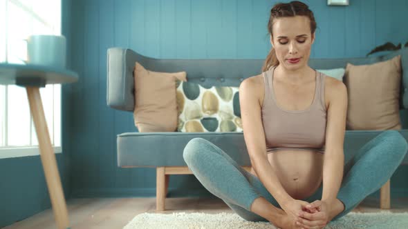 Expectant Mother Touching Belly After Workout. Pregnant Woman Making Yoga