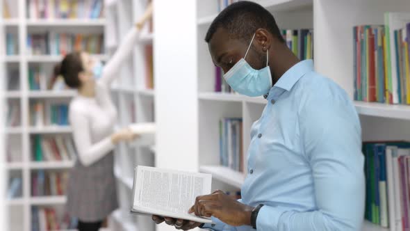 Masked Students Education in the Library with Books. Social Distance During COVID-19