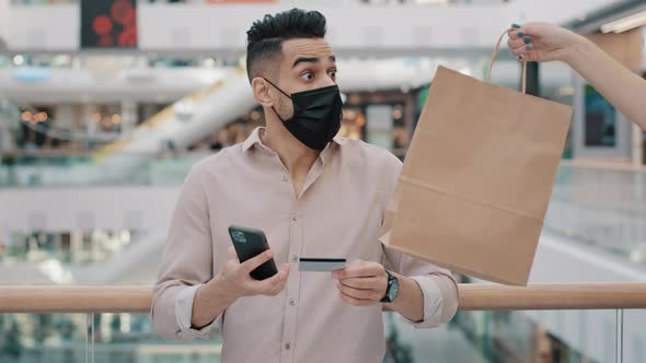 Indian Arabian Man in Medical Mask with Phone Pays Online Booking Mobile Service Food Delivery