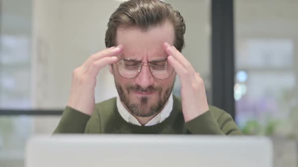 Close Up of Young Businessman Having Headache While Using Laptop
