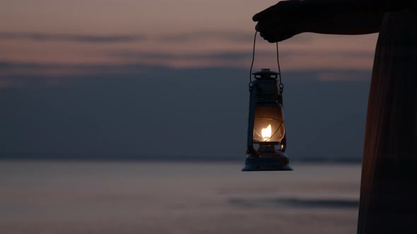 Girl Holding Old Lantern on Coast