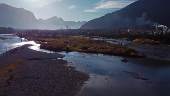 Factories in Mountains by river with smoke