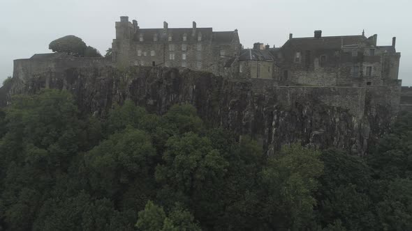 Close aerial pan from left to right of Stirling castle on a overcast day, showing battlements and tr