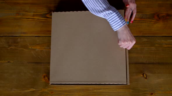 Top View  Woman Opening Box with Pizza