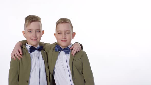 Smartly Dressed Identical Twins Posing in Studio alt
