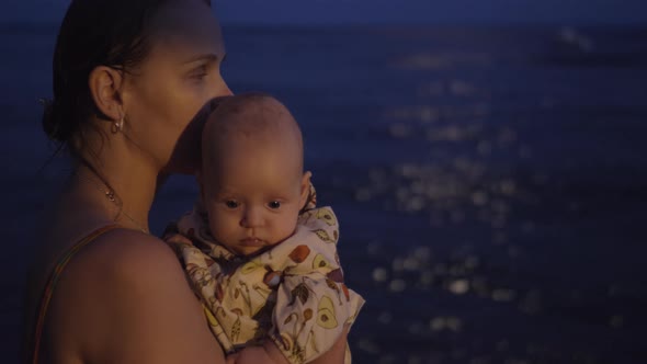 Mom with baby on the beach at night