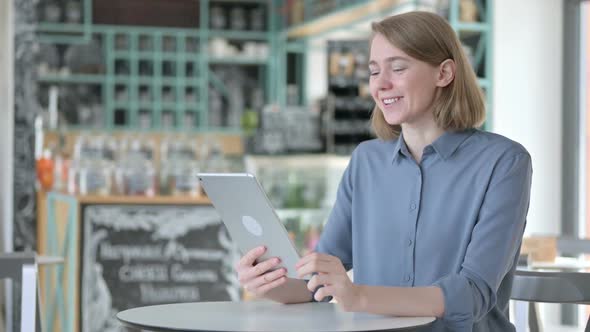 Video Call on Tablet By Beautiful Young Woman in Cafe