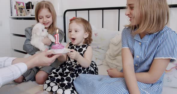 A Birthday Party for a Cute 1 Year Old Girl Surrounded By Her Older Sisters