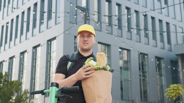 Close Up Handsome Courier Man Holding Paper Bag with Food at Street Outdoors