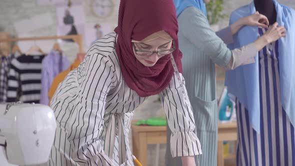 Young Muslim Women Fashion Designers at Work in a Modern Studio Close Up