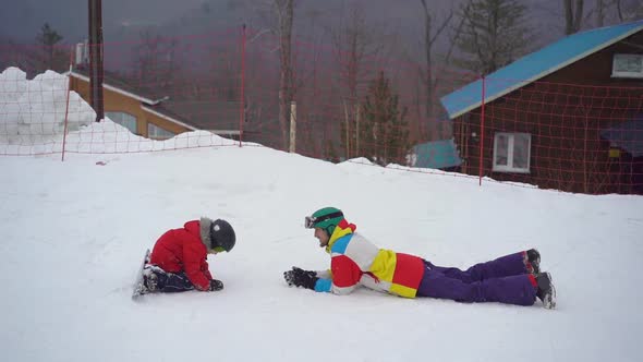 A Young Man and His Little Son Have Fun on a Ski Slope in a Mountain Resort Activities Park, Winter