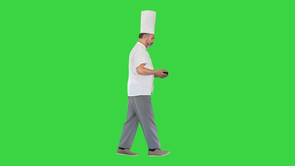 Bearded Man Cook Walking and Using Mobile Phone on a Green Screen Chroma Key