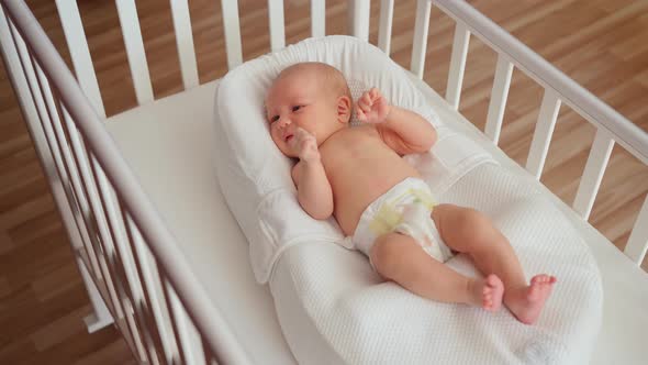 Newborn Baby Lies in a White Crib in Cocoonababy for Newborns Motherhood Childbirth