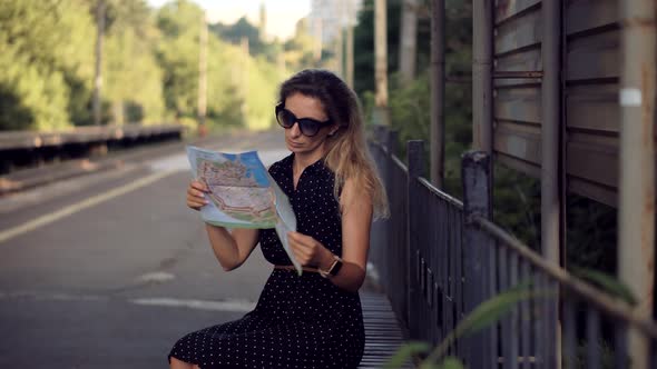 Female Traveler Waiting Train And Looking Town Plan On Navigation Map For Journey.