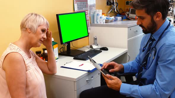 Doctor discussing with patient over digital tablet