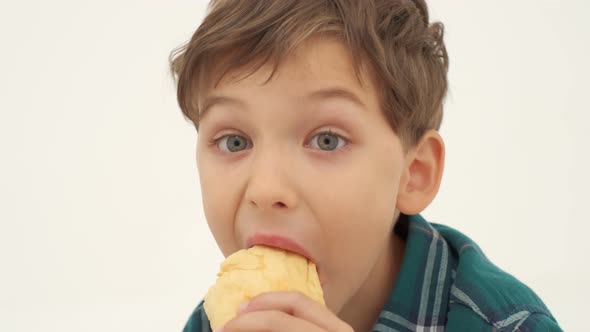 Boy with Slightly Dirty Face is Eating Hot Dog