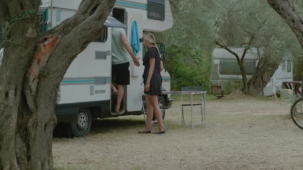 Traveler couple go to motor home RV campervan. Traveling in recreational vehicle