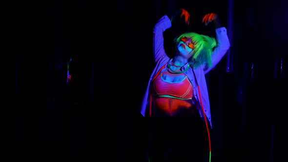 Gogo Dancer Woman is Moving in Nightclub Fluorescent Makeup and Wig in UV Lights on Dance Floor