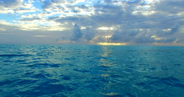 Wide angle overhead travel shot of a sandy white paradise beach and aqua blue water background in hi