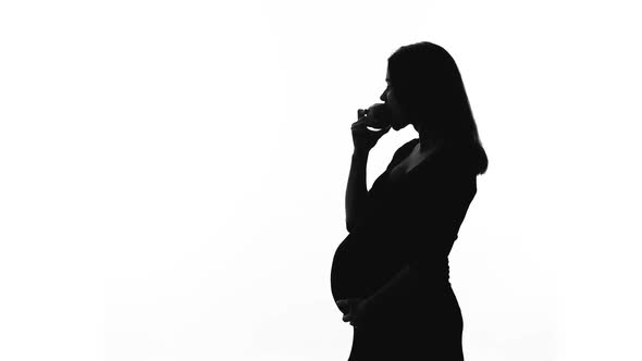 Silhouette of Pregnant Woman Eating Apple, Healthy Diet During Childbearing