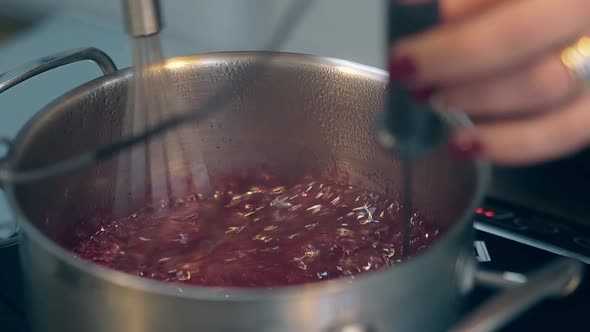 Woman Finishes Boiling Caramel and Regulates Temperature