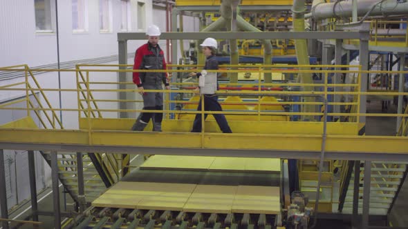 Two Friendly Engineers Greeting Each Other in Production Hall