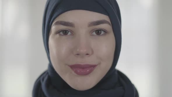 Portrait of a Young Smiling Eastern Woman in the Modern Muslim Clothes and Beautiful Black Headdress