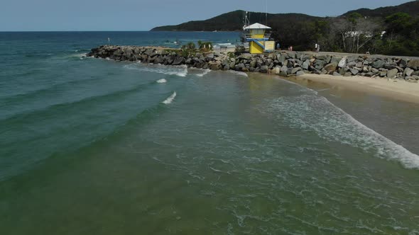 Drone flying along coast beach and shore of Noosa Heads in Australia. Aerial view