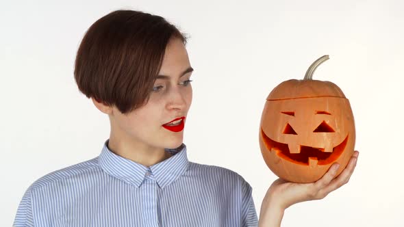 Beautiful Woman Smiling To the Camera, Holding Halloween Carved Pumpkin