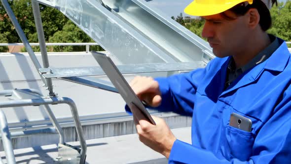 Male worker using digital tablet at solar station