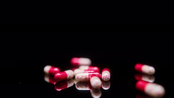 Closeup of Medicine Tablets on Black Background Shooting of Red and White Drugs on the Table