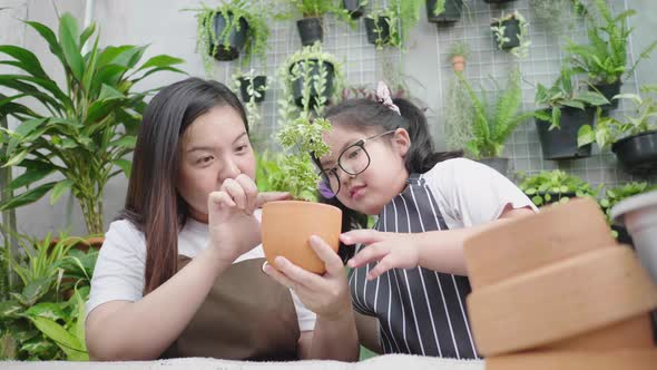 Asian cute child girl helps her mother to care for plants