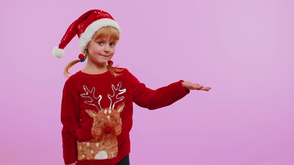 Girl in Red New Year Sweater Deer Showing Thumbs Up and Pointing at on Blank Advertisement Space