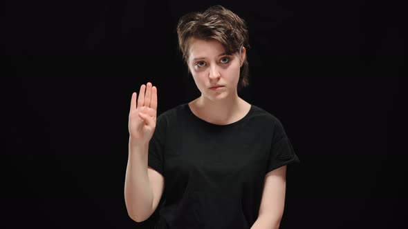 Sad Young Woman Showing Sign to Help Looking at Camera