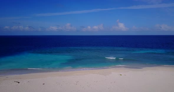 Beautiful birds eye copy space shot of a white sandy paradise beach and blue water background in vibrant