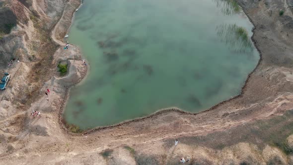 Aerial View of Car By the Edge of a Flooded Quarry