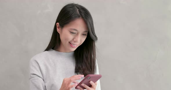 Woman use of mobile phone over grey background