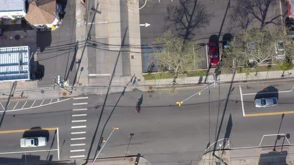 A top down shot taken over a quiet suburban neighborhood on a sunny day. The drone camera looking st